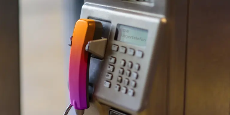 Ein Tastentelefon einer Telefonzelle mit einem Hörer in BSW Farben. Im LCD Textfeld des Gerätes steht BSW Bürgertelefon.